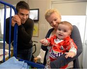 18 September 2013; Munster and Ireland Rugby star Conor Murray made a special visit to Temple Street Children’s University Hospital, as part of Temple Street’s 'Kiss Them Better' campaign. On the visit to the hospital Conor urged Irish families to buy Medicare plasters to support Temple Street. For every pack of Medicare plasters bought from pharmacies throughout the country, the Limerick based first-aid company will make a donation to the hospital's emergency equipment fund. Check out www.kissthembetter.ie for more information. Pictured with Conor Murray during the visit is 6-month-old Daniel Dempsey, from Clonakilty, Co. Cork, and his mother Yvonne Power. Temple Street Children's University Hospital, Temple Street, Dublin. Picture credit: Stephen McCarthy / SPORTSFILE