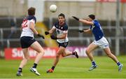 9 June 2024; Liam Kearney of New York handpasses to teammate Eoghan McElligot under pressure from Mark Barry of Laois during the Tailteann Cup preliminary quarter-final match between Laois and New York at Laois Hire O'Moore Park in Portlaoise, Laois. Photo by Tom Beary/Sportsfile