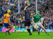 9 June 2024; Will O'Donoghue of Limerick side steps referee Colm Lyons as Mark Rodgers of Clare awaits developments during the Munster GAA Hurling Senior Championship final match between Clare and Limerick at FBD Semple Stadium in Thurles, Tipperary. Photo by Ray McManus/Sportsfile