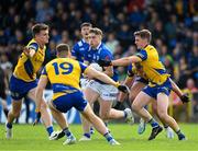 15 June 2024; Cormac O'Reilly of Cavan in action against Roscommon players, left to right, Shane Cunnane, Ronan Daly, and Robbie Dolan during the GAA Football All-Ireland Senior Championship Round 3 match between Cavan and Roscommon at Glennon Brothers Pearse Park in Longford. Photo by Daire Brennan/Sportsfile