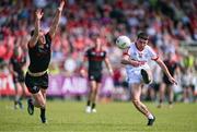 23 June 2024; Chris Óg Jones of Cork kicks a point despite the attention of Paul Mathews of Louth during the GAA Football All-Ireland Senior Championship preliminary quarter-final match between Louth and Cork at Grattan Park in Inniskeen, Monaghan. Photo by Ben McShane/Sportsfile