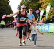 21 September 2013; Laura Gibney with her Goddaughter Aoife Brophy, aged three, from Dublin, in action during the half-marathon Airtricity Dublin race series. Phoenix Park, Dublin. Picture credit: Tomás Greally / SPORTSFILE