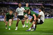 25 July 2024; Chay Mullins of Team Ireland goes over for his side's first try despite the tackle of Selesitino Ravutaumada of Team Fiji during the Men's Rugby Sevens Quarter-Final match between Team Fiji and Team Ireland at the Stade de France during the 2024 Paris Summer Olympic Games in Paris, France. Photo by Brendan Moran/Sportsfile