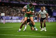 25 July 2024; Chay Mullins of Team Ireland goes over for his side's first try despite the tackle of Selesitino Ravutaumada of Team Fiji during the Men's Rugby Sevens Quarter-Final match between Team Fiji and Team Ireland at the Stade de France during the 2024 Paris Summer Olympic Games in Paris, France. Photo by Brendan Moran/Sportsfile