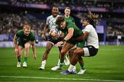 25 July 2024; Chay Mullins of Team Ireland goes over for his side's first try despite the tackle of Selesitino Ravutaumada of Team Fiji during the Men's Rugby Sevens Quarter-Final match between Team Fiji and Team Ireland at the Stade de France during the 2024 Paris Summer Olympic Games in Paris, France. Photo by Brendan Moran/Sportsfile