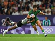 25 July 2024; Chay Mullins of Team Ireland is tackled by Iowane Teba of Team Fiji during the Men's Rugby Sevens Quarter-Final  match between Team Fiji and Team Ireland at the Stade de France during the 2024 Paris Summer Olympic Games in Paris, France. Photo by Brendan Moran/Sportsfile