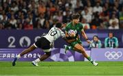 25 July 2024; Chay Mullins of Team Ireland is tackled by Iowane Teba of Team Fiji during the Men's Rugby Sevens Quarter-Final  match between Team Fiji and Team Ireland at the Stade de France during the 2024 Paris Summer Olympic Games in Paris, France. Photo by Brendan Moran/Sportsfile