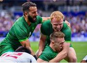 27 July 2024; Terry Kennedy of Team Ireland, bottom, celebrates with team-mates Mark Roche, left, and Gavin Mullin after scoring his side's third try during the men's placing 5-8 match between Team Ireland and Team USA at the Stade de France during the 2024 Paris Summer Olympic Games in Paris, France. Photo by Sandra Ruhaut/Sportsfile