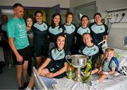 5 August 2024; Anna Maria O'Donoghue, Anna Galvin, Louise Ní Mhuircheartaigh, Cáit Lynch, Eilís Lynch Aisling O'Connor and Niamh Carmody from TG4 All-Ireland Ladies Senior Football Champions Kerry are pictured with the Brendan Martin Cup and three year old Dylan O'Sullivan with his mum Flora and dad Eoghan, from Glenbeigh, in Kerry, during a visit by the players to Children's Health Ireland at Crumlin, Dublin. Photo by Ray McManus/Sportsfile