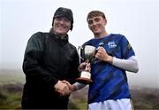 5 August 2024; Matthew O'Sullivan of Kerry is presented the winning trophy for the U16 Hurling by Uachtarán Chumann Lúthchleas Gael Jarlath Burns during the 2024 M. Donnelly GAA All-Ireland Poc Fada Finals at Annaverna Mountain in the Cooley Peninsula, Ravensdale, Louth. Photo by Ben McShane/Sportsfile