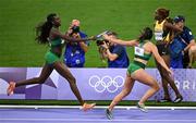 10 August 2024; Phil Healy of Team Ireland receives the baton from teammate Rhasidat Adeleke during the women's 4x400 relay final  at the Stade de France during the 2024 Paris Summer Olympic Games in Paris, France. Photo by Stephen McCarthy/Sportsfile
