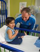 23 September 2013; Dublin manager Jim Gavin with three year old Ayeman Hassan, from Clonee, Co Meath, as the Sam Maguire cup was taken on a visit by the All-Ireland Senior Football Champions to Temple Street Children's University Hospital, Temple Street, Dublin.  Picture credit: Ray McManus / SPORTSFILE