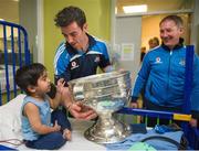 23 September 2013; Dublin's Michael Darragh MacAuley, and manager Jim Gavin, with three year old Ayeman Hassan, from Clonee, Co Meath, and the Sam Maguire cup on a visit by the All-Ireland Senior Football Champions to Temple Street Children's University Hospital, Temple Street, Dublin.  Picture credit: Ray McManus / SPORTSFILE