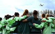 28 September 2024; A plane flies overhead a the Republic of Ireland team huddle before the women's U17 international friendly match between Republic of Ireland and Cymru at the AUL Complex in Clonsaugh, Dublin. Photo by Shauna Clinton/Sportsfile