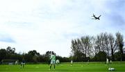 28 September 2024; An airplane flies overhead as Republic of Ireland players warm-up before the women's U17 international friendly match between Republic of Ireland and Cymru at the AUL Complex in Clonsaugh, Dublin. Photo by Shauna Clinton/Sportsfile