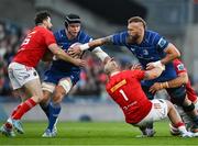 12 October 2024; RG Snyman of Leinster offloads to teammate James Ryan as he is tackled by Jeremy Loughman and Jean Kleyn of Munster during the United Rugby Championship match between Leinster and Munster at Croke Park in Dublin. Photo by Brendan Moran/Sportsfile