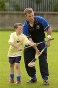 24 August 2004; Ten year old Ciaran Walsh, from Irishtown,  under the watchful eye of Tipperary U21 captain Diarmuid Fitzgerald at the Dublin Docklands Festival of Football and Hurling, for 10-14 year olds from the Docklands area, at Parnell Park, Dublin. Picture credit; Ray McManus / SPORTSFILE