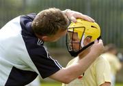 24 August 2004; Ten year old Ryan Savage, from Irishtown,  has his helmet adjusted by coach Nick English at the Dublin Docklands Festival of Football and Hurling, for 10-14 year olds from the Docklands area, at Parnell Park, Dublin. Picture credit; Ray McManus / SPORTSFILE