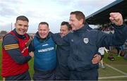 26 October 2024; Joe O'Leary, left, Ireland manager Michael Kavanagh, Kevin O'Brien and Damien Coleman, right, celebrate after the Shinty International match between Ireland and Scotland at Cusack Park in Ennis, Clare. Photo by Ray McManus/Sportsfile
