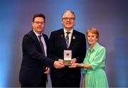8 November 2024; Brendan Crossan, left, of The Irish News accepts the Best National Media Award from Uachtarán Chumann Lúthchleas Gael Jarlath Burns, alongside Maureen McNaughton, sister of the late John McKillop, during the 2023 GAA MacNamee Awards at Croke Park in Dublin. Photo by Piaras Ó Mídheach/Sportsfile