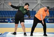 16 November 2024; James Egan from Ferbane, Offaly, tries out shot put with the help of VI Para Hub coordinator Tracey Percy during the PTSB NextGen Community Series at the National Indoor Arena on the Sport Ireland Campus in Dublin. Paralympics Ireland hosted the latest in the PTSB NextGen Community Series at the Sport Ireland National Indoor Arena on Saturday. This programme is open to people over 10 with a visual, intellectual, or physical impairment, allowing them to ‘come and try’ Para sports and learn about opportunities in their local areas. Photo by Seb Daly/Sportsfile