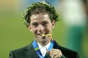 27 August 2004; Ireland's Cian O'Connor bites his Gold Medal after winning the Individual Jumping Competition on Waterford Crystal. Markopoulo Olympic Equestrian Centre. Games of the XXVIII Olympiad, Athens Summer Olympics Games 2004, Athens, Greece. Picture credit; Brendan Moran / SPORTSFILE