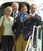 30 August 2004; Olympic gold medalist Cian O'Connor with girlfriend Rachel Wise shows off his gold medal on the arrival home of the Irish Olympic team from Athens. Dublin Airport, Dublin. Picture credit; Pat Murphy / SPORTSFILE