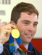 30 August 2004; Olympic gold medalist Cian O'Connor shows off his medal during a press conference on the arrival home of the Irish Olympic team from Athens. Dublin Airport, Dublin. Picture credit; Pat Murphy / SPORTSFILE