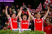 30 November 2024; Cuala players, from left, Niall O'Callaghan, Eoghan O'Callaghan and Con O'Callaghan lift the McCabe Cup after their side's victory in the AIB Leinster GAA Senior Club Football Championship final match between Cuala of Dublin and Ardee St Mary's of Louth at Croke Park in Dublin. Photo by Ben McShane/Sportsfile