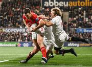 20 December 2024; Tom Farrell of Munster on his way to scoring his side's first try despite the tackle of Stuart McCloskey and Werner Kok of Ulster during the United Rugby Championship match between Ulster and Munster at Kingspan Stadium in Belfast. Photo by Ramsey Cardy/Sportsfile