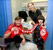 23 December 2024; Shelbourne player Sean Boyd with John Paul Mullins, age 5, and his mother Isabella Wilczek during a visit to CHI at Temple Street in Dublin. Photo by David Fitzgerald/Sportsfile