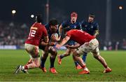 27 December 2024; Joe McCarthy of Leinster is tackled by Rory Scannell, left, and Brian Gleeson of Munster during the United Rugby Championship match between Munster and Leinster at Thomond Park in Limerick. Photo by Brendan Moran/Sportsfile