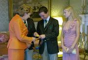 1 September 2004; Irish showjumper Cian O'Connor, in the company of his girlfriend Rachel Wise and Irish Chef de Mission William O'Brien (hidden), takes out his Gold Medal to show to President Mary McAleese, at a reception, held in Aras an Uachtarain, in honour of the Irish team's achievement at the 2004 Olympic Games in Athens recently. Picture credit; Brendan Moran / SPORTSFILE