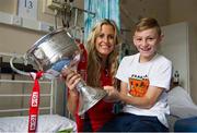 30 September 2013; Cork's Brid Stack with Derek McDonnell, from Cabra, Dublin, and the Brendan Martin cup on a visit by the All-Ireland Ladies Football Champions to Temple Street Children's University Hospital, Temple Street, Dublin.  Picture credit: Brendan Moran / SPORTSFILE