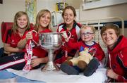 30 September 2013; Cork players, from left, Roisin Phelan, Elaine Harte, Anne Marie Walsh and Aine Hayes, with Patrick Smyth, age 3, from Ballylynan, Co. Laois, and the Brendan Martin cup on a visit by the All-Ireland Ladies Football Champions to Temple Street Children's University Hospital, Temple Street, Dublin.  Picture credit: Brendan Moran / SPORTSFILE