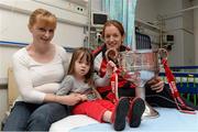 30 September 2013; Cork captain Ann Marie Walsh with Lucie Masterson, age 3, from Rathfarnham, Co. Dublin, and her mother Tanya and the Brendan Martin cup on a visit by the All-Ireland Ladies Football Champions to Temple Street Children's University Hospital, Temple Street, Dublin.  Picture credit: Brendan Moran / SPORTSFILE