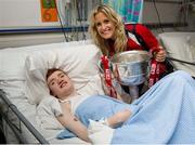30 September 2013; Cork's Brid Stack with Conor Moran, from Whitehall, Dublin, and the Brendan Martin cup on a visit by the All-Ireland Ladies Football Champions to Temple Street Children's University Hospital, Temple Street, Dublin.  Picture credit: Brendan Moran / SPORTSFILE