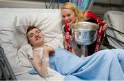 30 September 2013; Cork's Vera Foley with Conor Moran, from Whitehall, Dublin, and the Brendan Martin cup on a visit by the All-Ireland Ladies Football Champions to Temple Street Children's University Hospital, Temple Street, Dublin.  Picture credit: Brendan Moran / SPORTSFILE