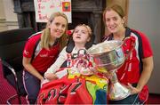 30 September 2013; Cork's Nollaig Cleary, left, and Ann Marie Walsh with Jodi Traynor, from Greenore, Co. Louth, and the Brendan Martin cup on a visit by the All-Ireland Ladies Football Champions to Temple Street Children's University Hospital, Temple Street, Dublin.  Picture credit: Brendan Moran / SPORTSFILE