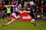 2 February 2025; Cork goalkeeper Patrick Doyle kicks a point under pressure from Peter Fegan of Down during the Allianz Football League Division 2 match between Down and Cork at Páirc Esler in Newry, Down. Photo by Ramsey Cardy/Sportsfile
