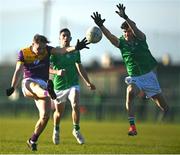 2 February 2025; Mark Rossiter of Wexford scores a point despite the attempted block by Andrew Meade of Limerick during the Allianz Football League Division 4 match between Limerick and Wexford at Mick Neville Park in Rathkeale, Limerick. Photo by Tom Beary/Sportsfile