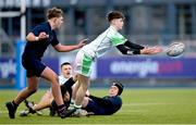 4 February 2025; Cian Benson of Gonzaga College offloads the ball despite the efforts of Sean Lee of Wesley College during the Bank of Ireland Leinster Rugby Boys Schools Junior Cup First Round match between Wesley College and Gonzaga College at Energia Park in Dublin. Photo by Shauna Clinton/Sportsfile