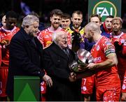 7 February 2025; President of Ireland Michael D Higgins and FAI President Paul Cooke, left, present the FAI President's Cup to Shelbourne captain Mark Coyle after the 2025 Men's FAI President's Cup final match between Shelbourne and Drogheda United at Tolka Park in Dublin. Photo by Stephen McCarthy/Sportsfile