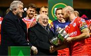 7 February 2025; President of Ireland Michael D Higgins and FAI President Paul Cooke, left, present the FAI President's Cup to Shelbourne captain Mark Coyle after the 2025 FAI President's Cup final match between Shelbourne and Drogheda United at Tolka Park in Dublin. Photo by Shauna Clinton/Sportsfile