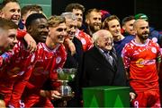 7 February 2025; Shelbourne players and staff celebrate with the FAI President's Cup in the company of President of Ireland Michael D Higgins and FAI President Paul Cooke after the 2025 FAI President's Cup final match between Shelbourne and Drogheda United at Tolka Park in Dublin. Photo by Shauna Clinton/Sportsfile