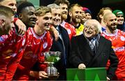 7 February 2025; Shelbourne players and staff celebrate with the FAI President's Cup in the company of President of Ireland Michael D Higgins and FAI President Paul Cooke after the 2025 FAI President's Cup final match between Shelbourne and Drogheda United at Tolka Park in Dublin. Photo by Shauna Clinton/Sportsfile