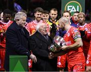 7 February 2025; President of Ireland Michael D Higgins, in the company of FAI President Paul Cooke hands the FAI President's Cup over to winning Shelbourne captain Mark Coyle after the 2025 Men's FAI President's Cup final match between Shelbourne and Drogheda United at Tolka Park in Dublin. Photo by Stephen McCarthy/Sportsfile