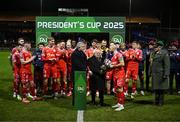 7 February 2025; President of Ireland Michael D Higgins, in the company of FAI President Paul Cooke hands the FAI President's Cup over to winning Shelbourne captain Mark Coyle after the 2025 Men's FAI President's Cup final match between Shelbourne and Drogheda United at Tolka Park in Dublin. Photo by Stephen McCarthy/Sportsfile