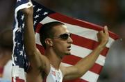28 August 2004; Jeremy Wariner of the USA celebrates with the US flag after he and his team-mates won Gold in the Men's 4 x 400m Final. Olympic Stadium. Games of the XXVIII Olympiad, Athens Summer Olympics Games 2004, Athens, Greece. Picture credit; Brendan Moran / SPORTSFILE