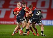 15 February 2025; Gavin Coombes of Munster is tackled by Ioan Lloyd, left, and Johnny Williams of Scarlets during the United Rugby Championship match between Munster and Scarlets at Thomond Park in Limerick. Photo by David Fitzgerald/Sportsfile